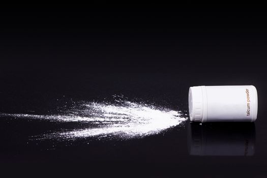 white talcum powder splash on black background, health concept