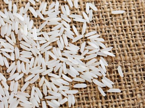 Thai jasmine rice in sack, white rice on burlap sack background with rice grain close up