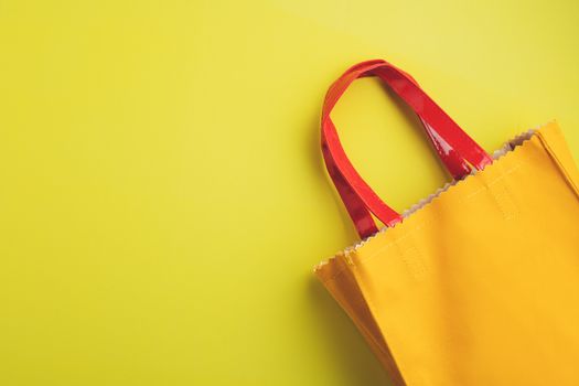 Yellow leather reusable bag on yellow background with copy space for green environmentally friendly concept 