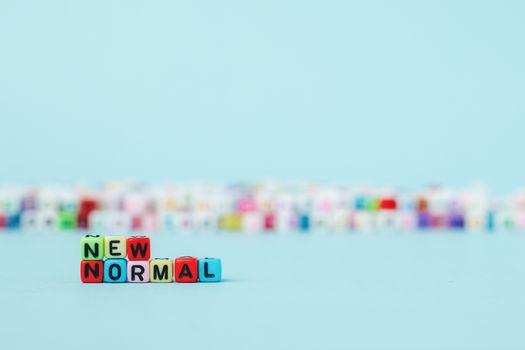 NEW NORMAL word with letter beads on blue background for a new way of living concept
