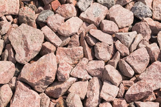Macro of pink crushed stones (angular rock) used for road construction