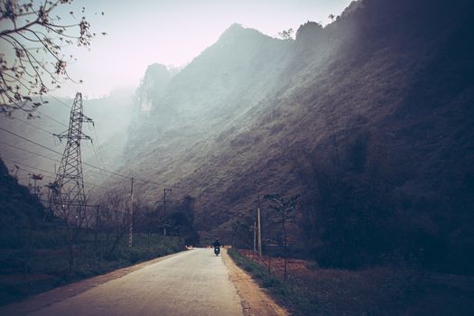 Dark and moody cinematic scenery of the fog covered mountain road in Meo vac, Ha giang Province in North Vietnam