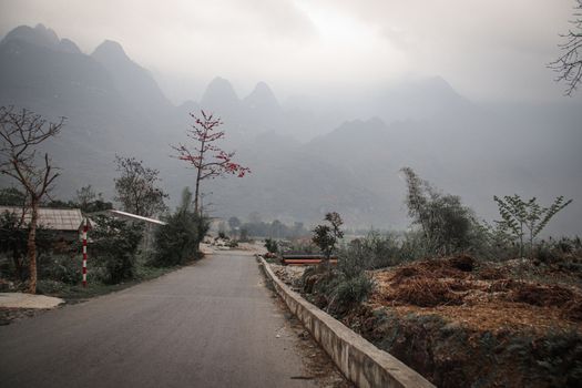 Dark and moody cinematic scenery of the fog covered mountain road in Meo vac, Ha giang Province in North Vietnam