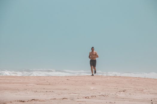 Jogging alone on the beach shows the new normal style of fitness during the covid-19 pandemic