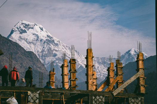 An unfinished house construction against the majestic view of Annapurna Mountain range