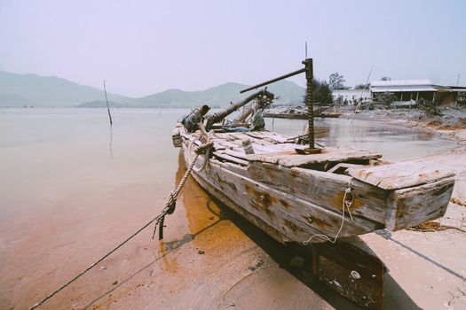 Old wooden vietnamese fishing boat in Qhuy nhon fishing village in Vietnam that shows the local culture and livelihood