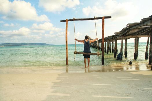 Enjoying the beach swing in tropical summer Koh Rong Island in Cambodia