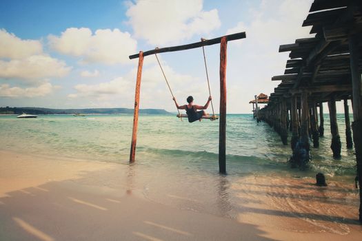 Enjoying the beach swing in tropical summer Koh Rong Island in Cambodia