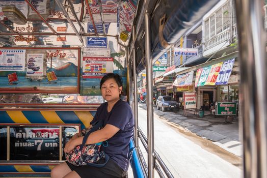 Bangkok, Thailand - June 10, 2017 : Asia women 40s white skin prepare a fare on a minibus car for a passenger travel in city to destination