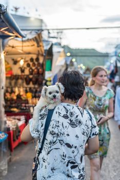 Prachuap Khiri Khan, Thailand - June 17, 2017 : Unidentified woman and the dog walk stroll shopping at Hua Hin night market. The famous night market for travel in Hua Hin is major tourist attraction.