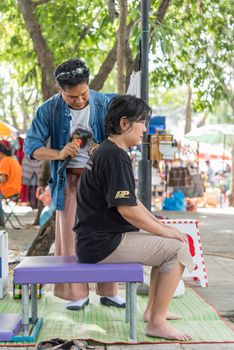 Bangkok, Thailand - July 28, 2017 : Unidentified Thai woman to take of service Thai massage by wooden hammer for treat aches and pains. The service comes in the outdoor garden.