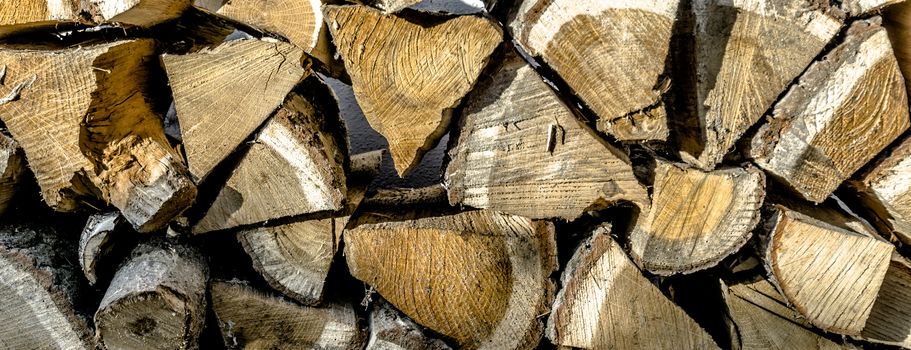 Close-up view of a stack of chopped wood for the fireplace fire in winter, background or wallpaper