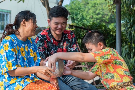 Ang Thong, Thailand - April 13, 2018 : Unidentified Asian young bathe with respect to parents by water have a jasmine and rose flower and aromatherapy in water in water bowl in Songkran Festival