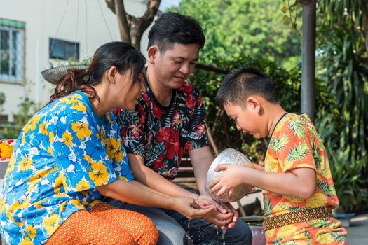 Ang Thong, Thailand - April 13, 2018 : Unidentified Asian young bathe with respect to parents by water have a jasmine and rose flower and aromatherapy in water in water bowl in Songkran Festival