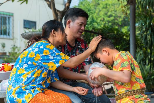 Ang Thong, Thailand - April 13, 2018 : Unidentified Asian young bathe with respect to parents by water have a jasmine and rose flower and aromatherapy in water in water bowl in Songkran Festival