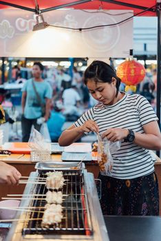 Bangkok, Thailand -  April 26, 2018 : Unidentified chef cooking a Mala is Grilled meat (Beef, Pork, Chickens or Mushroom) with chilli sauce and sichuan pepper for sale at street food market.