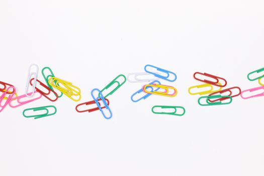 colorful paperclips on white office desk