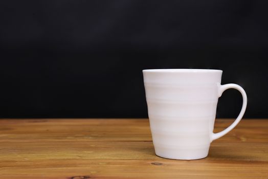 a white porcelain coffee mug on a brown wooden table