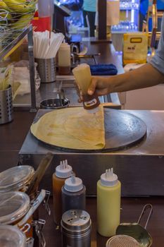 Bangkok, Thailand -  June 5, 2016 : Unidentified chef cooking a crepe is a sweet food for sale at Thai street dessert food market.