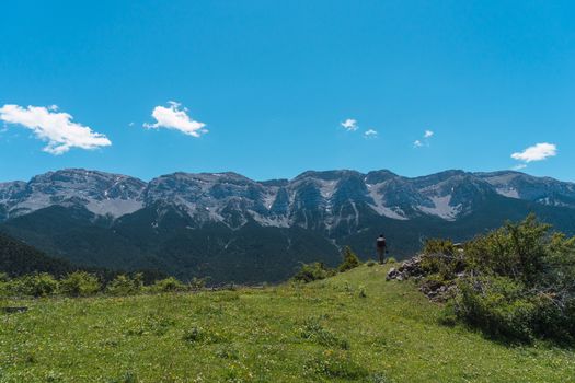 Young male photographer with backpack, hiker, walking through the mountains, inside the wild