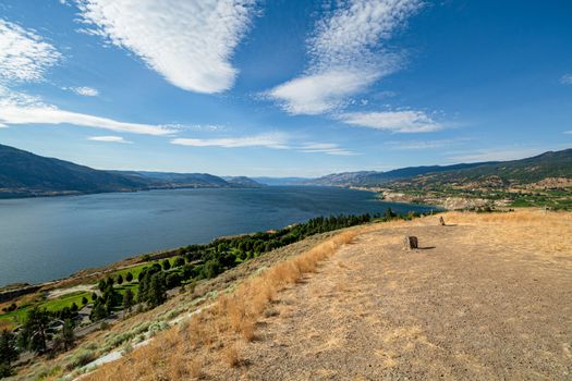 Magnificent view over Okanagan lake and valley with bizarre clouds in the sky. Stones of solar calendar on the hill