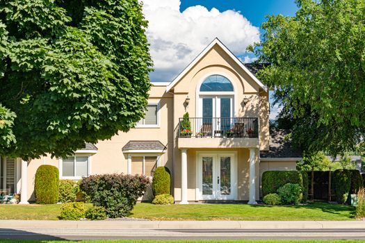 A perfect neighbourhood. Luxury residential townhouse with private entrance among the trees on cloudy sky background