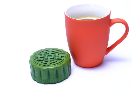 green tea flavor moon-cake and a mug of hot coffee isolated on white background