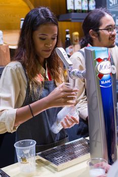 Bangkok, Thailand - May 28, 2016 : Unidentified barman or bartender pouring a draught lager beer from beer tap on counter for serving in a restaurant or pub.