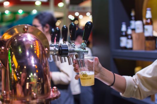 Bangkok, Thailand - May 28, 2016 : Unidentified barman or bartender pouring a draught lager beer from beer tap on counter for serving in a restaurant or pub.