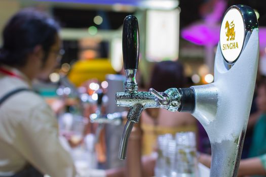 Bangkok, Thailand - May 28, 2016 : Unidentified barman or bartender pouring a draught lager beer from beer tap on counter for serving in a restaurant or pub.