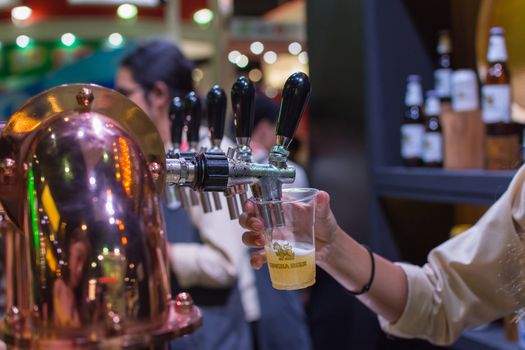 Bangkok, Thailand - May 28, 2016 : Unidentified barman or bartender pouring a draught lager beer from beer tap on counter for serving in a restaurant or pub.