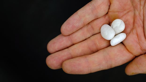 a man handing out three small white pebbles