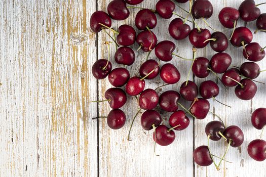 A heap of fresh red cherries on wooden background.