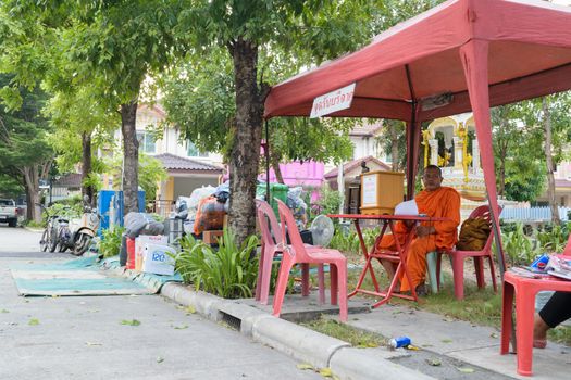 Bangkok, Thailand - October 14, 2015 : Thai monk volunteer waiting for donation at village in Don Mueang district.