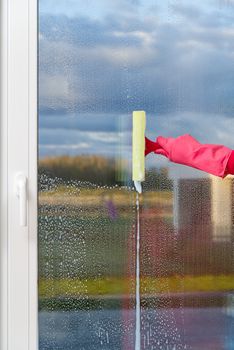 attractive wife washing a window. Gloved hand cleaning window rag and spray. washing windows. cleaning service concept