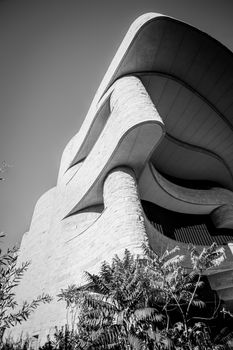 Curving lines and architectural lines of National Museum of American Indian in monochrome in WAshington DC, USA.