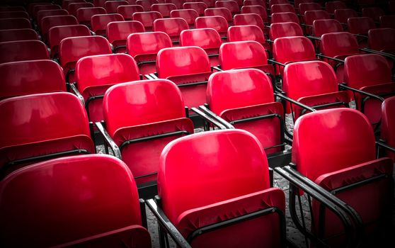 Empty plastic red chairs In outdoor theater in sunny day. Close Up.