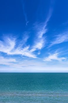 Vertical view of a amazing sea and blue sky with puffy clouds