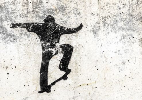 View of a skateboarding themed stencil graffiti piece by an unidentified artist on grungy wall. It can be used as a urban theme, poster, wallpaper, design t-shirts and more.