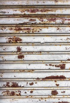 Old rusted weathered metal folding vertical gate