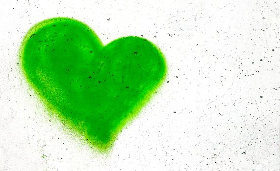 Green heart shaped on grungy wall background with copy space