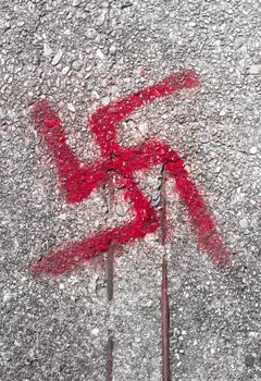 Graffiti on road floor of the svastika symbol.