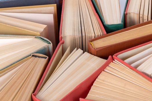 Many different old hardcover physical books close-up background with selective focus and blur.