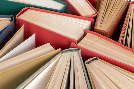 Many different old hardcover physical books close-up background with selective focus and blur.