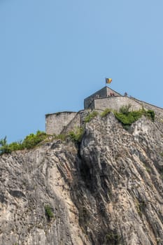 Dinant, Belgium - June 26, 2019: Closeup of fish eye view of Citadelle front top with Belgian flag and people.
