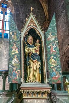 Dinant, Belgium - June 26, 2019: Inside Collégiale Notre Dame de Dinant Church. Painted statue in its own niche of Sainte Regina Madonna, mother and child.