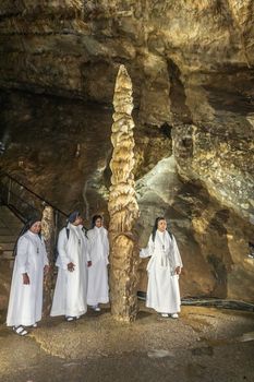 Han-sur-Lesse, Belgium - June 25, 2019: Grottes-de-Han 12 of 36. subterranean pictures of Stalagmites and stalactites in different shapes and colors throughout tunnels, caverns and large halls.. Four South Indian nuns.
