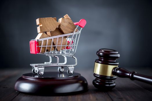 gavel justice hammer and wood house in shopping cart, house auction