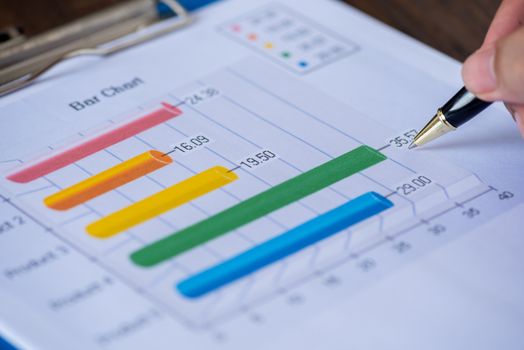 hand using a pen point on critical point in bussiness graph sheet