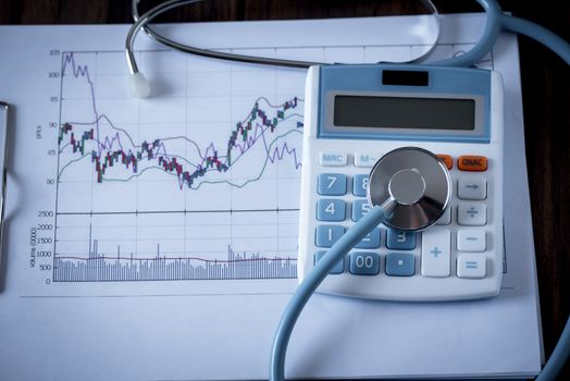 Medical stethoscope on calculator and business graph sheet , business analysis concept